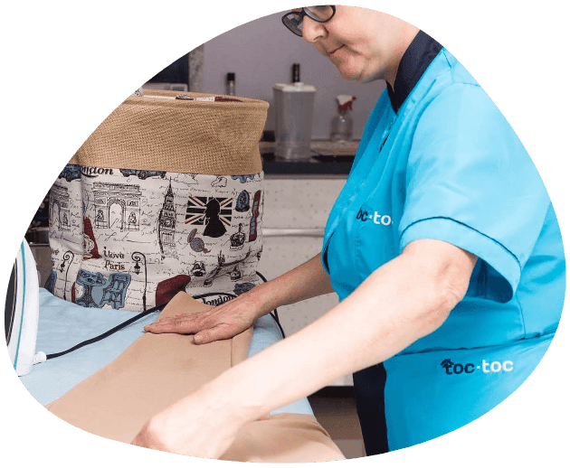 senora de aseo planchando ropa