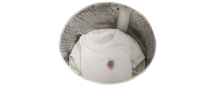 Camiseta blanca con mancha de tinte dentro de lavadora