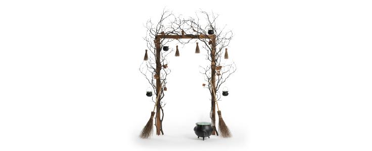 Entrada decorada con ramas, escobas miniatura y calderos colgantes